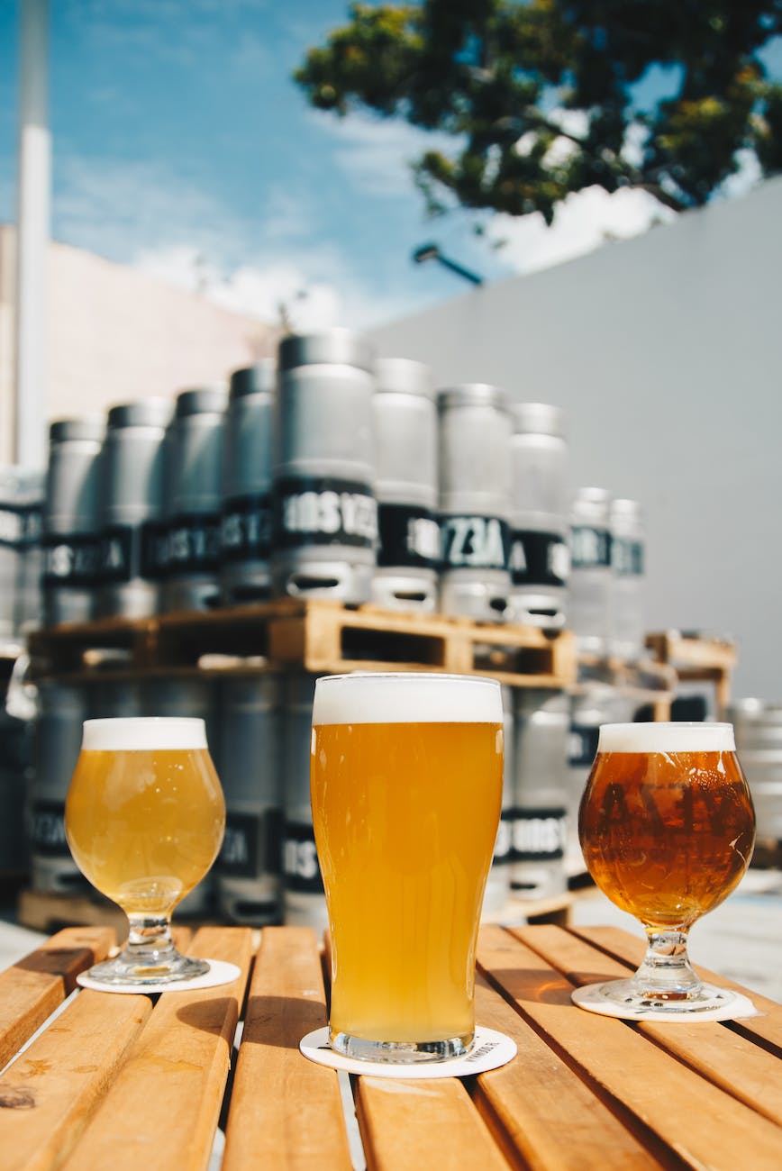 three assorted drinking glasses with beer